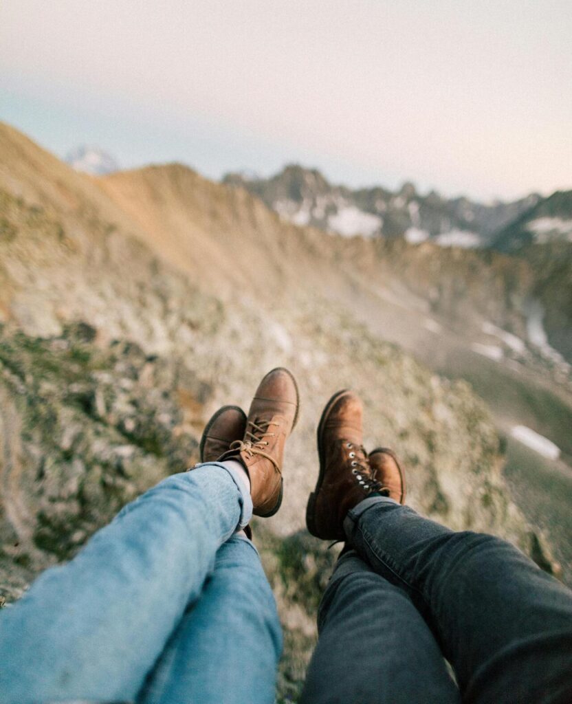 two people on a cliff after walking on a scenic Italian mountain trail.