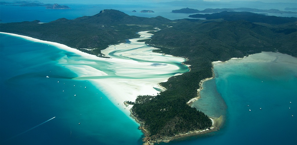 Aerial view of Whitehaven Beach in the Whitsundays, with swirling white sand, turquoise water and forested coastline